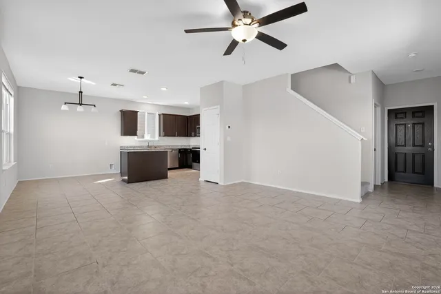 a view of a livingroom with a ceiling fan kitchen view and a window