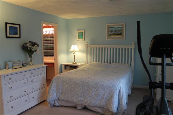 133 Patrick Road, Unit 133 Tewksbury, MA 01876 - Photo 22 of 30 a bedroom with a bed a dresser and next to a window