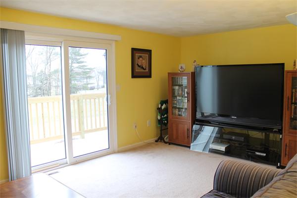 133 Patrick Road, Unit 133 Tewksbury, MA 01876 - Photo 4 of 30 a living room with furniture and a flat screen tv