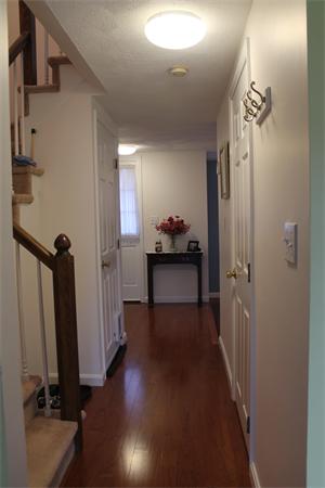 133 Patrick Road, Unit 133 Tewksbury, MA 01876 - Photo 8 of 30 a view of a hallway with a room that has a couch