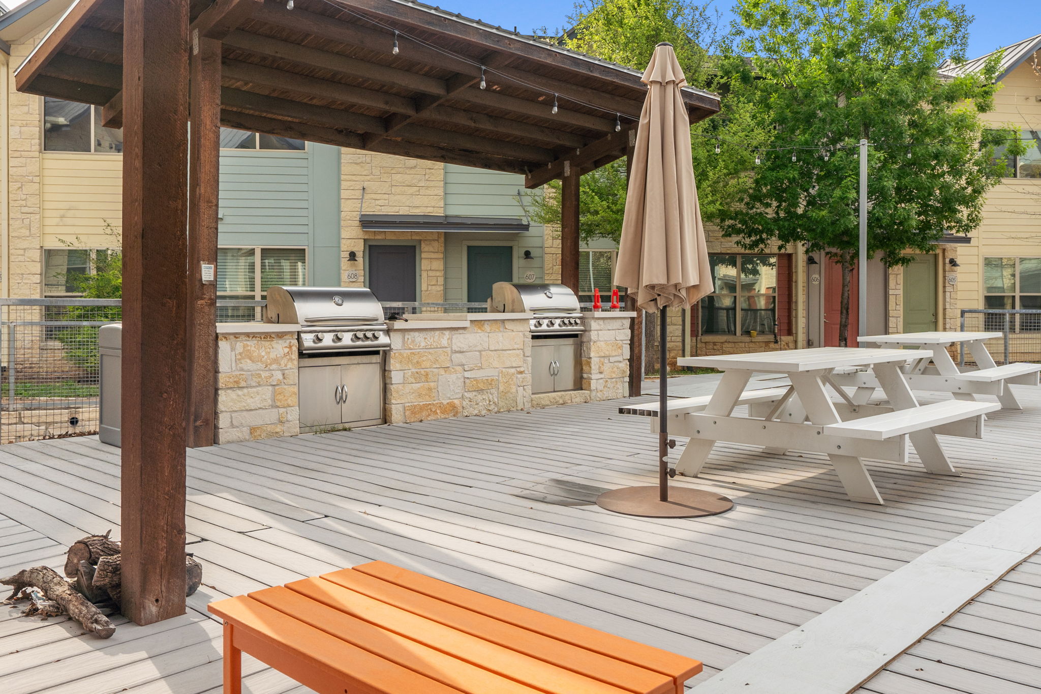 7805 Cooper Lane, Unit 606 Austin, TX 78745 - Photo 28 of 35 a view of a patio with table and chairs couches fire pit and wooden floor