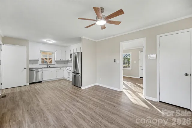 a view of a kitchen with wooden floor and a ceiling fan