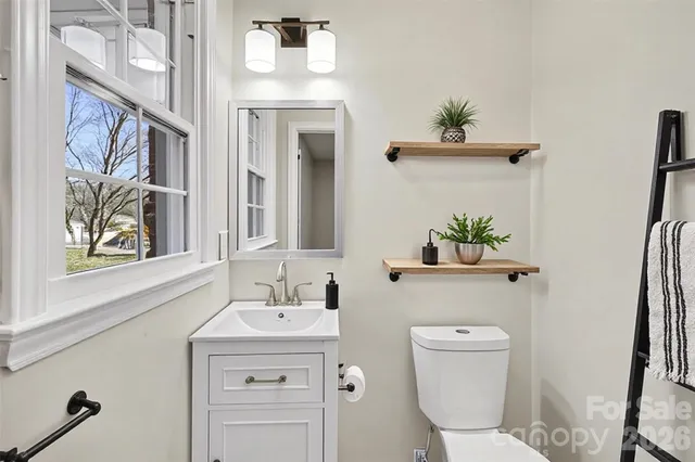 a bathroom with a toilet sink and a mirror