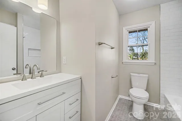 a bathroom with a toilet a sink and a mirror
