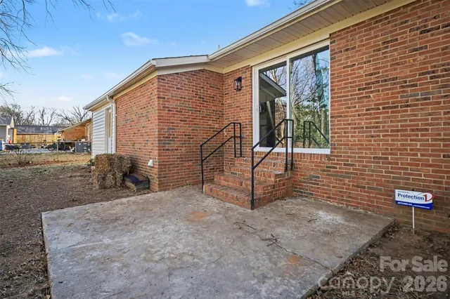 a view of backyard with barbeque grill and brick wall