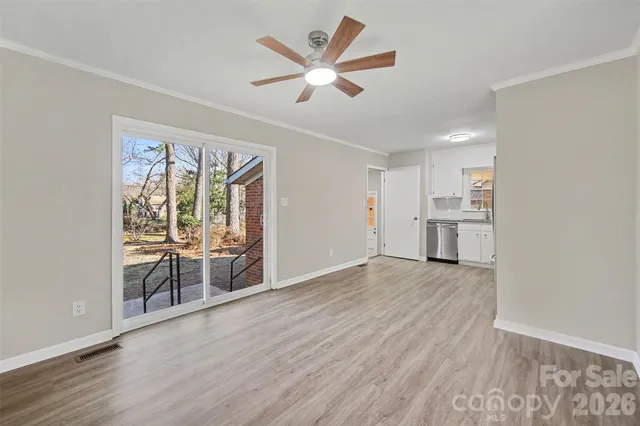 a view of empty room with wooden floor and ceiling fan