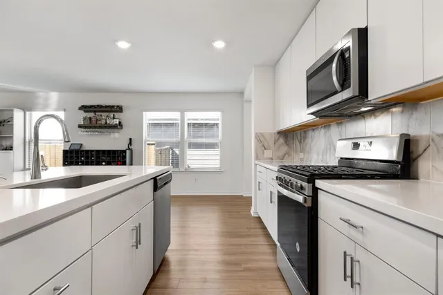 a kitchen with stainless steel appliances granite countertop a sink and stove top oven