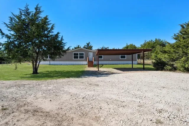 a view of a house with a yard and sitting area