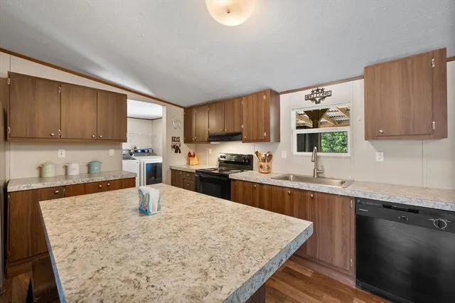 a kitchen with granite countertop a sink and cabinets