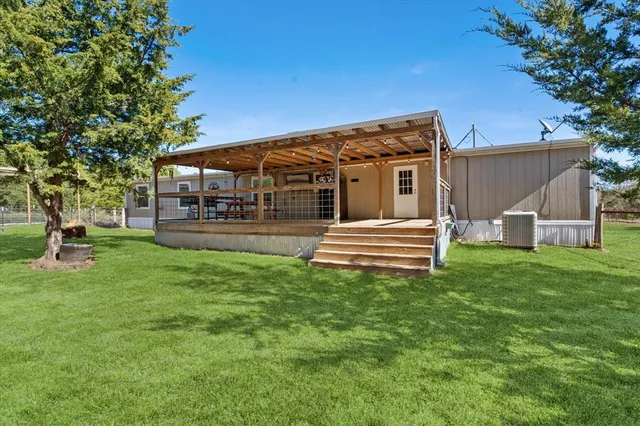 a view of a house with backyard and a tree