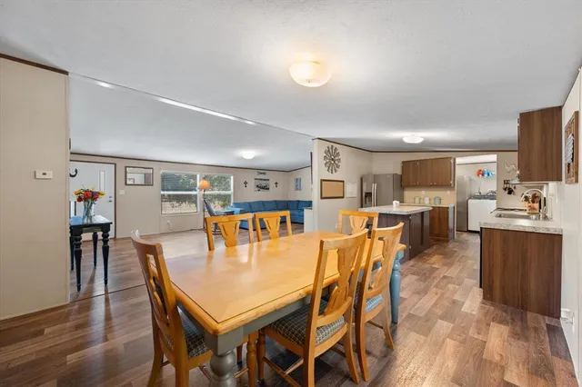 a dining room with stainless steel appliances kitchen island a table and chairs