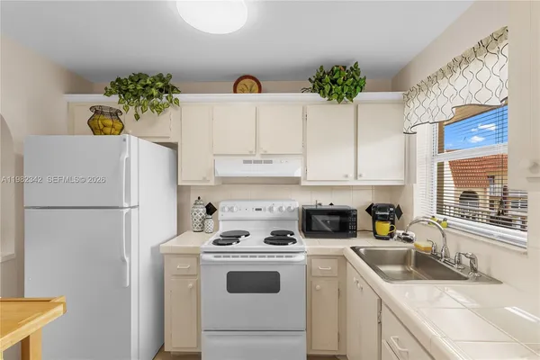 a kitchen with kitchen island a white counter top space and cabinets