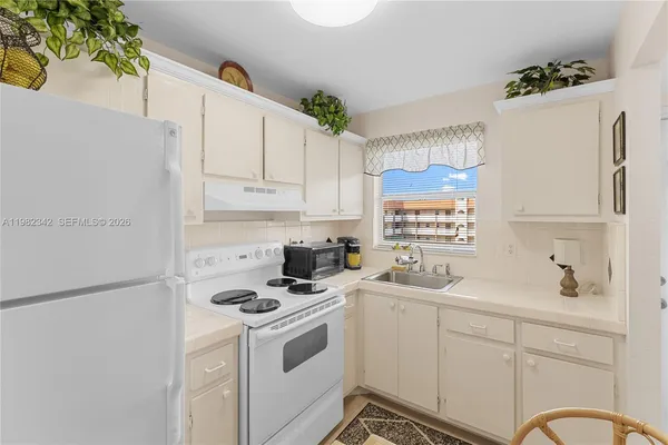 a kitchen with a sink stove and white refrigerator