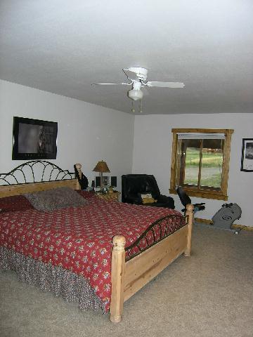 1055 225th Road Rifle, CO 81650 - Photo 5 of 9 a bedroom with a bed and a chandelier