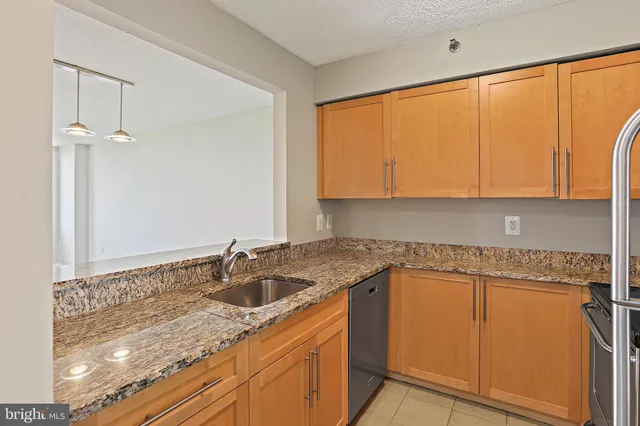 a kitchen with granite countertop sink and cabinets