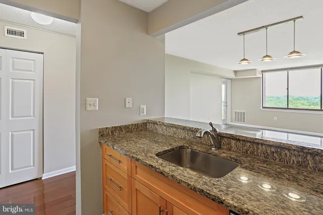 a kitchen with a sink granite counter tops and a window