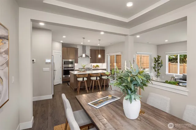 a dining room with furniture and potted plants