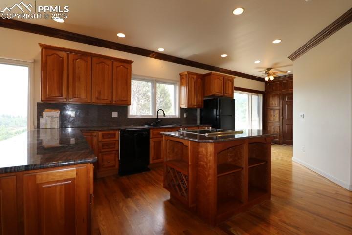 4015 Ramshorn Point Colorado Springs, CO 80904 - Photo 12 of 44 a kitchen with stainless steel appliances granite countertop wooden cabinets a refrigerator a sink a stove a microwave and wooden floors