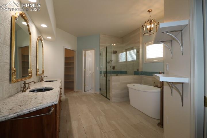 4015 Ramshorn Point Colorado Springs, CO 80904 - Photo 18 of 44 a spacious bathroom with a granite countertop sink a toilet a mirror and shower