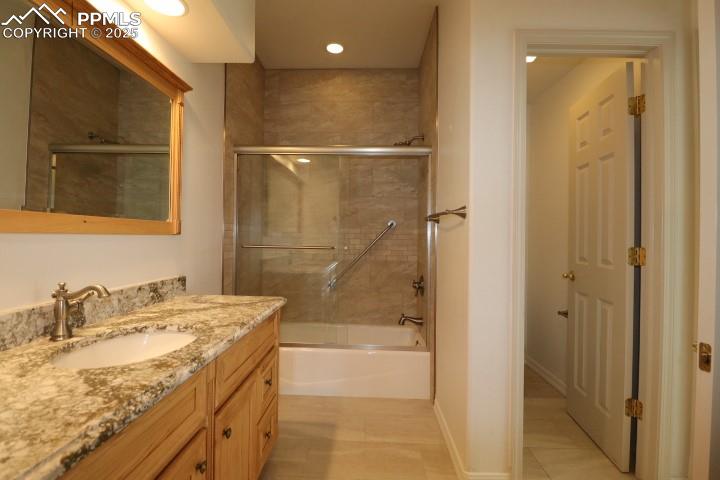 4015 Ramshorn Point Colorado Springs, CO 80904 - Photo 31 of 44 a bathroom with a granite countertop sink a mirror and shower