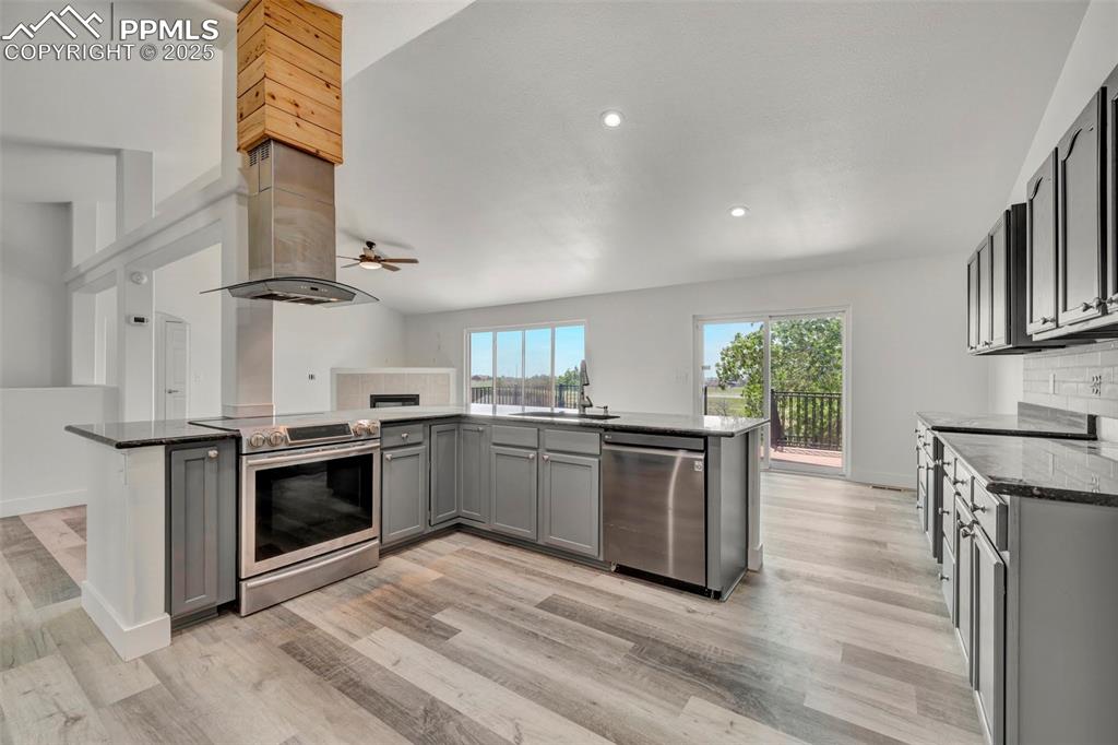 7841 Fort Smith Road Peyton, CO 80831 - Photo 6 of 37 Close up and personal view of kitchen with new gleaming appliances, cabinets, with lovely granite perfectly accenting the gray cabinetry.