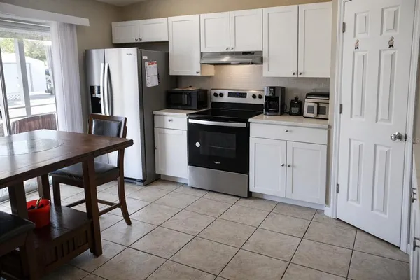 a kitchen with stainless steel appliances a refrigerator sink and cabinets
