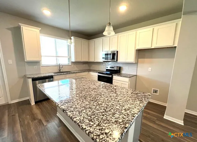 a kitchen with wooden floors and a window