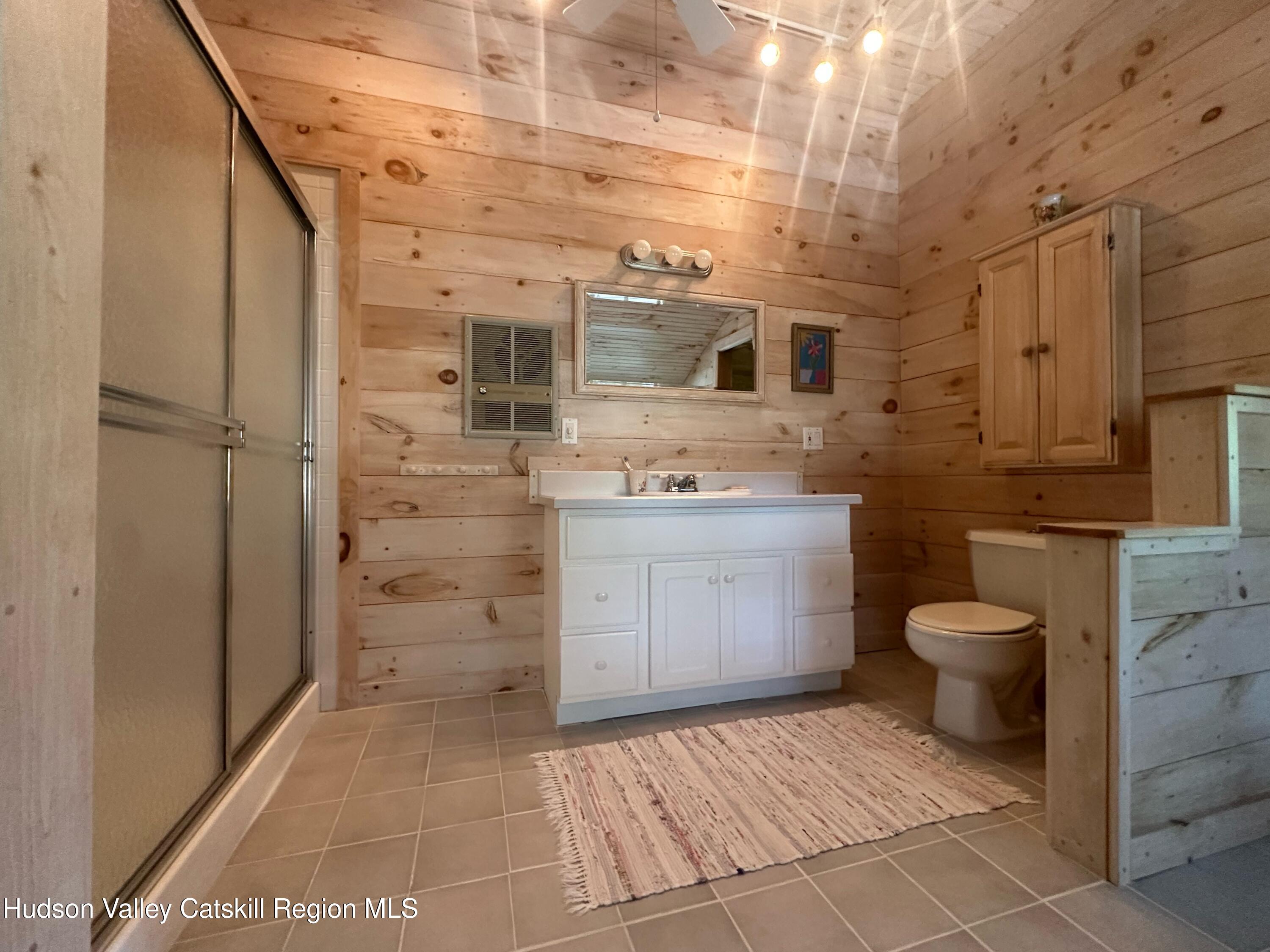 1492 County Road Copake, NY 12516 - Photo 16 of 34 a bathroom with a granite countertop toilet a sink and a mirror