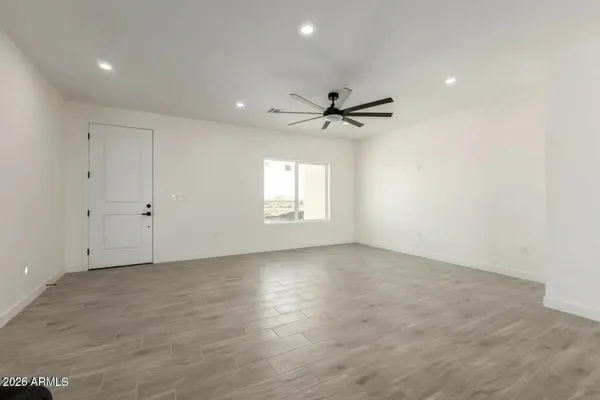 an empty room with windows and fan