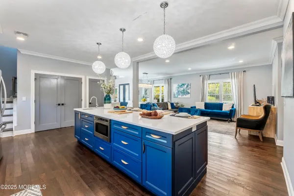 a large kitchen with lots of counter space a sink appliances and wooden floor