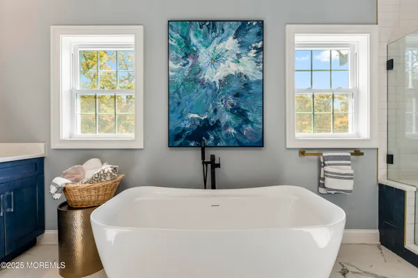 a white bath tub sitting in a bathroom next to a window
