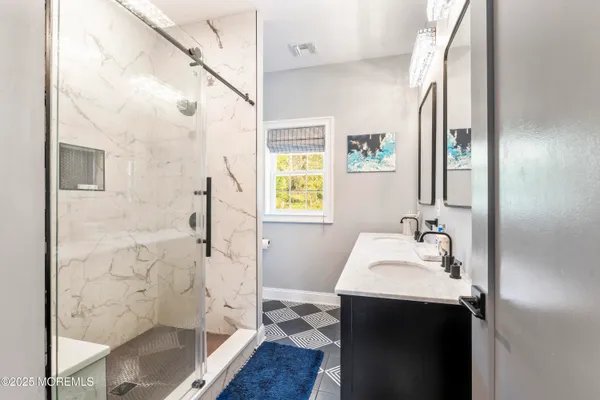 a bathroom with a sink a mirror and a shower