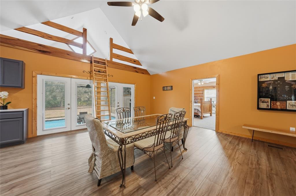 9796 Southwest Southern Dreams Road Arcadia, FL 34269 - Photo 13 of 72 a dining room with wooden floor a chandelier a glass table and chairs