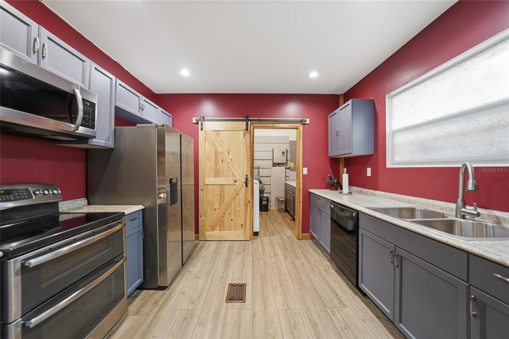9796 Southwest Southern Dreams Road Arcadia, FL 34269 - Photo 17 of 72 a kitchen with stainless steel appliances kitchen island granite countertop a stove a sink and a refrigerator