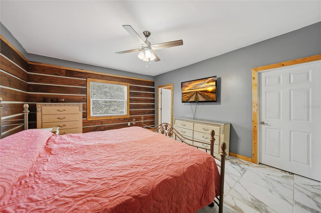 9796 Southwest Southern Dreams Road Arcadia, FL 34269 - Photo 21 of 72 a bedroom with a large bed and a chandelier