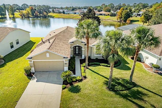 a front view of a house with a yard and palm trees