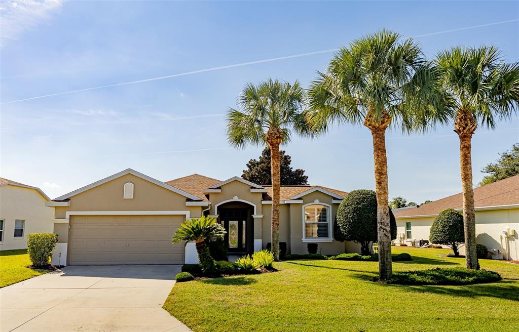 1250 Southwest 152nd Lane Ocala, FL 34473 - Photo 2 of 88 a front view of a house with a yard and palm trees
