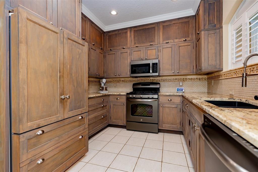 1250 Southwest 152nd Lane Ocala, FL 34473 - Photo 61 of 88 a kitchen with granite countertop a stove sink and cabinets