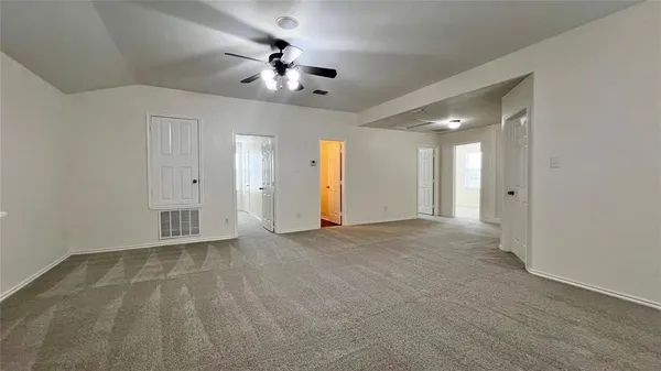 a view of an empty room with a chandelier fan