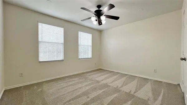 an empty room with chandelier fan
