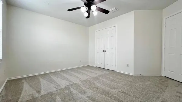 an empty room with windows and fan