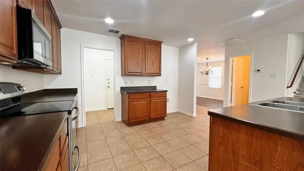 a kitchen with stainless steel appliances granite countertop a refrigerator and a stove top oven