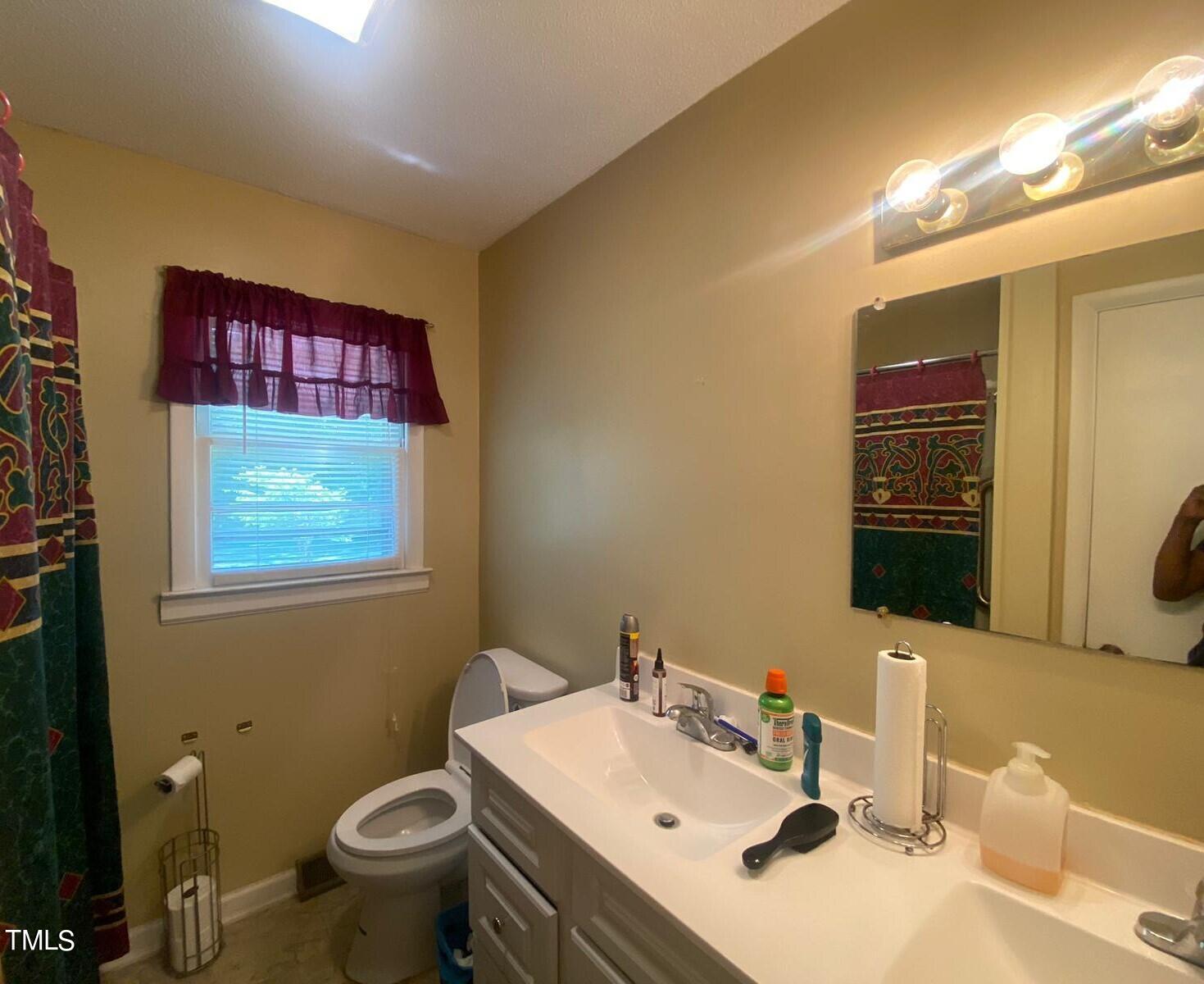 3933 Lizard Lick Road Wendell, NC 27591 - Photo 18 of 25 a bathroom with a sink mirror and toilet
