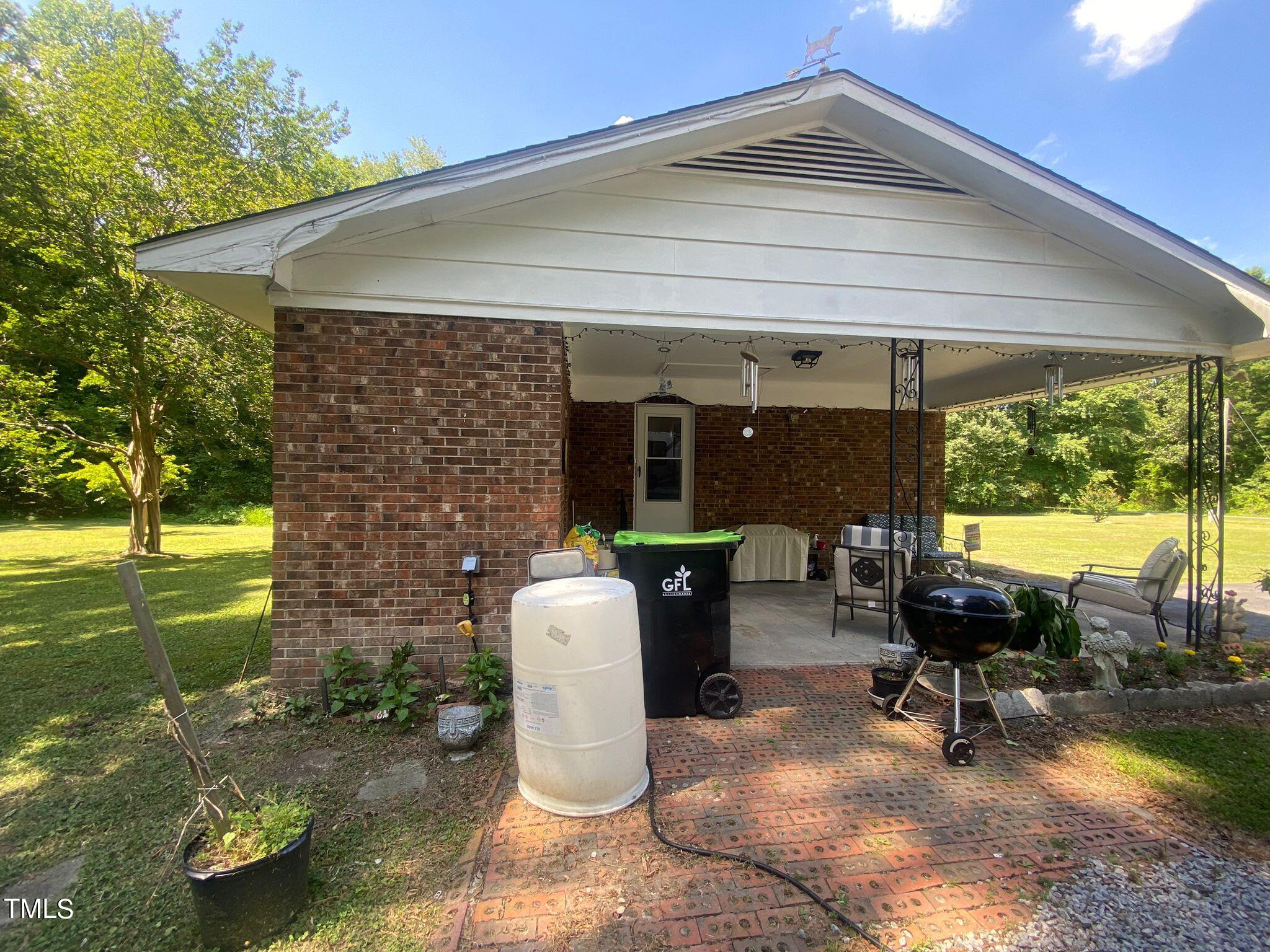 3933 Lizard Lick Road Wendell, NC 27591 - Photo 23 of 25 a view of a patio with table and chairs near a yard