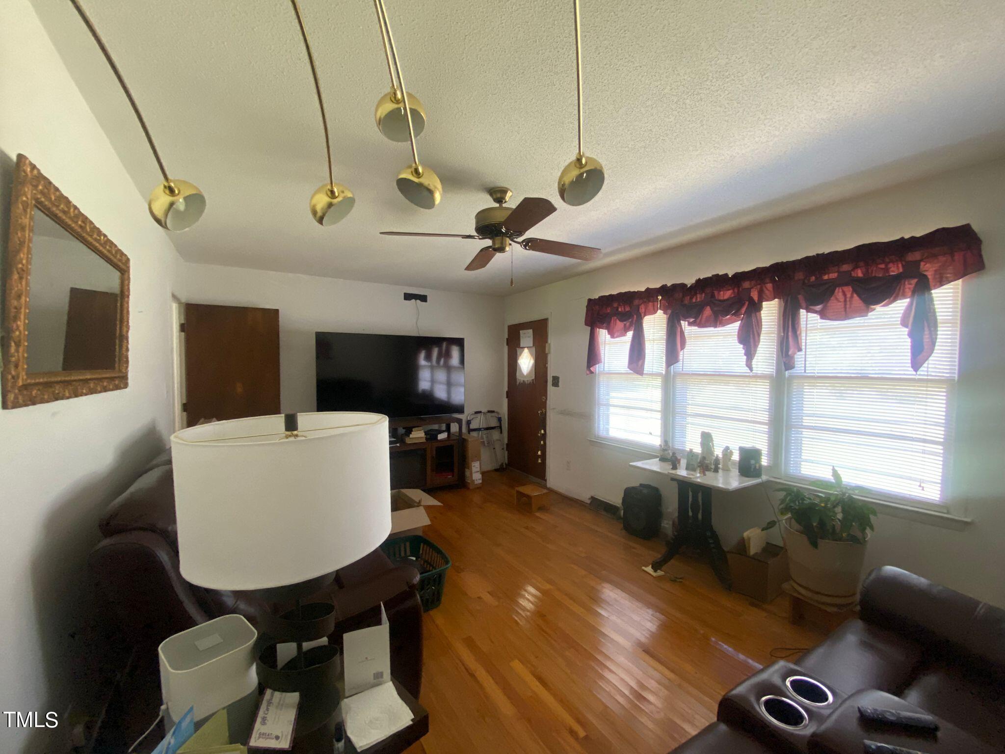 3933 Lizard Lick Road Wendell, NC 27591 - Photo 6 of 25 a living room with furniture a flat screen tv and a large window
