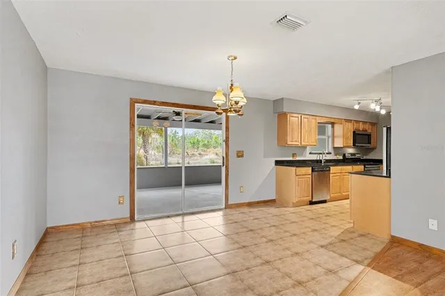 a view of a kitchen with kitchen island granite countertop a refrigerator and a stove top oven