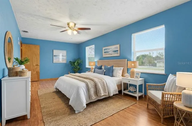 a spacious bedroom with a bed and a chair