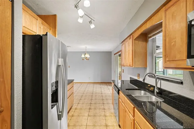 a bathroom with a granite countertop sink and a large mirror