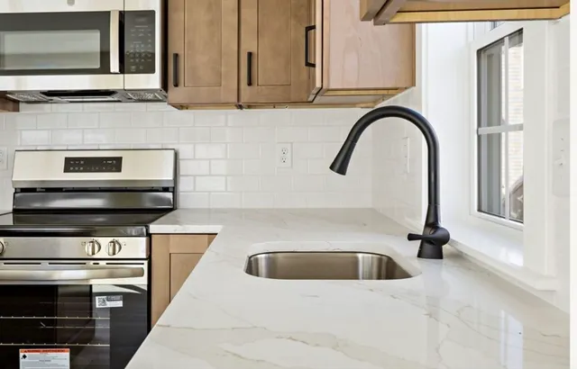 a kitchen with granite countertop a refrigerator and a sink
