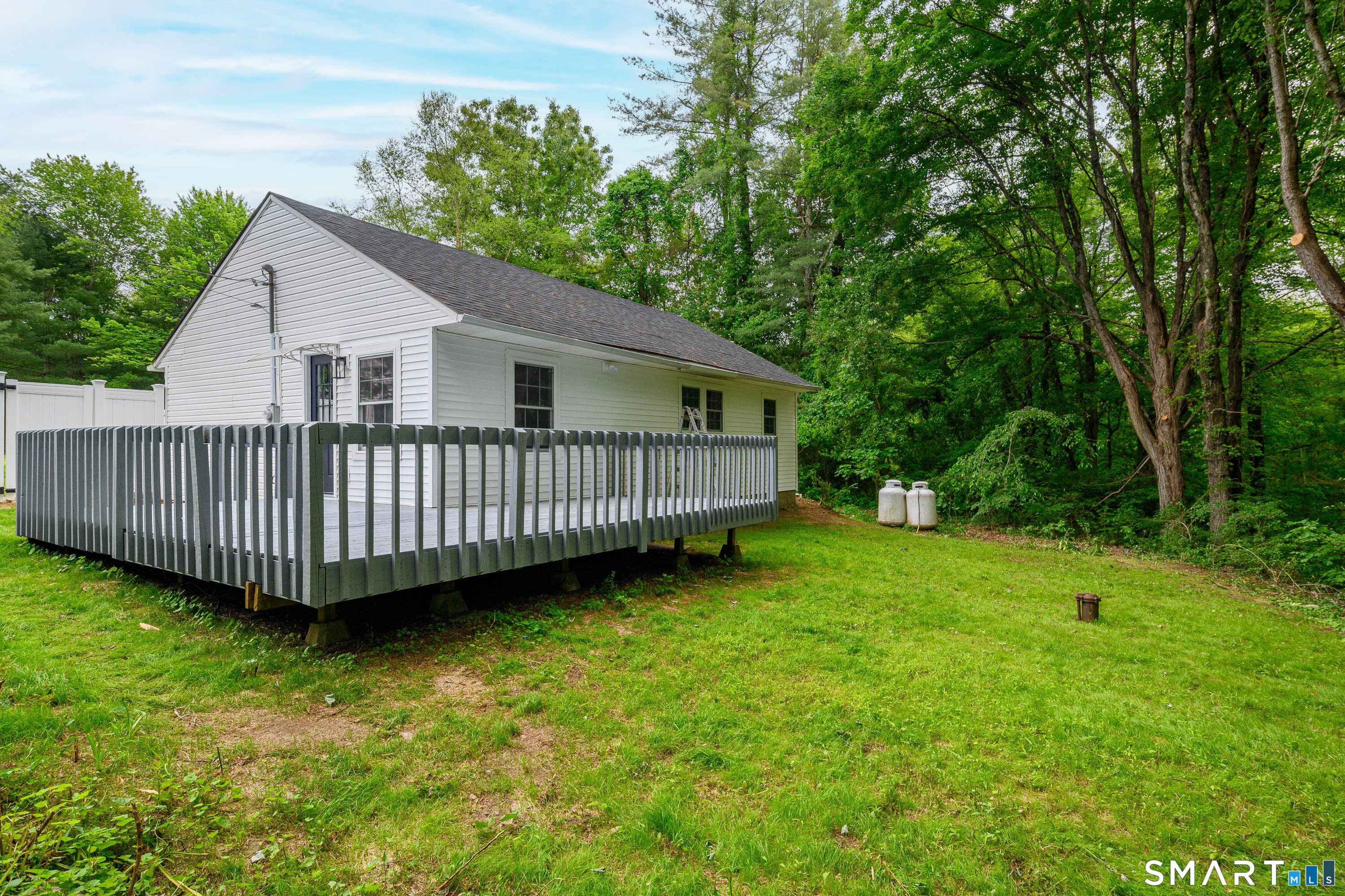 3 Botsford Hill Road Newtown, CT 06470 - Photo 22 of 25 Rear exterior view showcasing elevated deck and natural backyard setting.